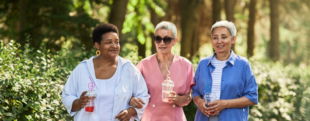Group of women walking in park and holding drinks